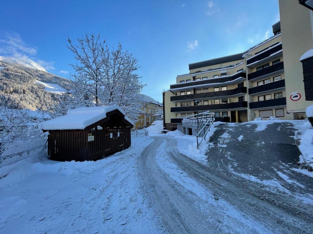 a snow covered road with a building and a building at Grenzberg Top 20 in Bad Gastein