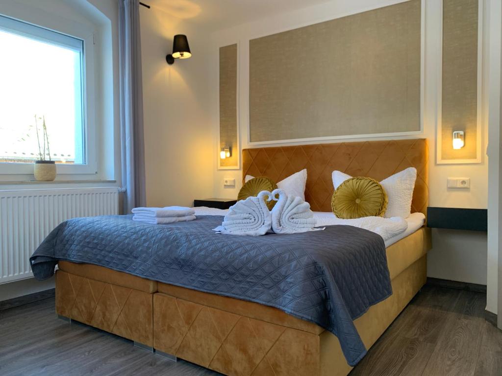 Pension Gesundbrunnen في Müglitztal: غرفة نوم بسرير كبير عليها مناشف