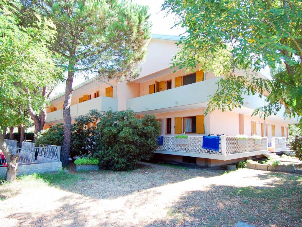 een groot wit gebouw met bomen ervoor bij Apartment Casa Lucrezia-5 by Interhome in Rosolina Mare