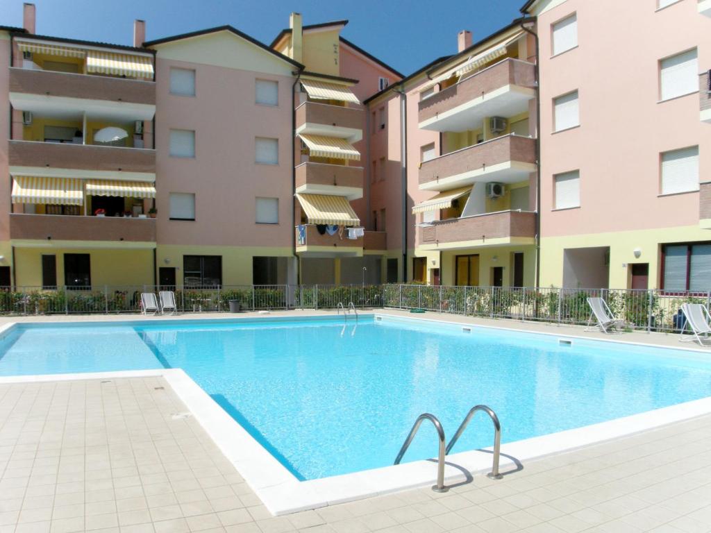 an image of a swimming pool in front of apartment buildings at Apartment Acquamarina-2 by Interhome in Rosapineta