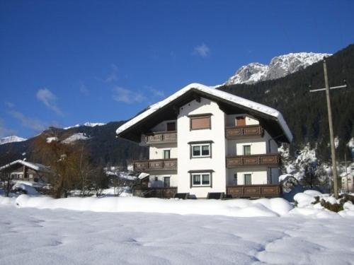 un edificio cubierto de nieve con techo cubierto de nieve en Ferienwohnungen/Holiday Apartments Lederer, en Reisach