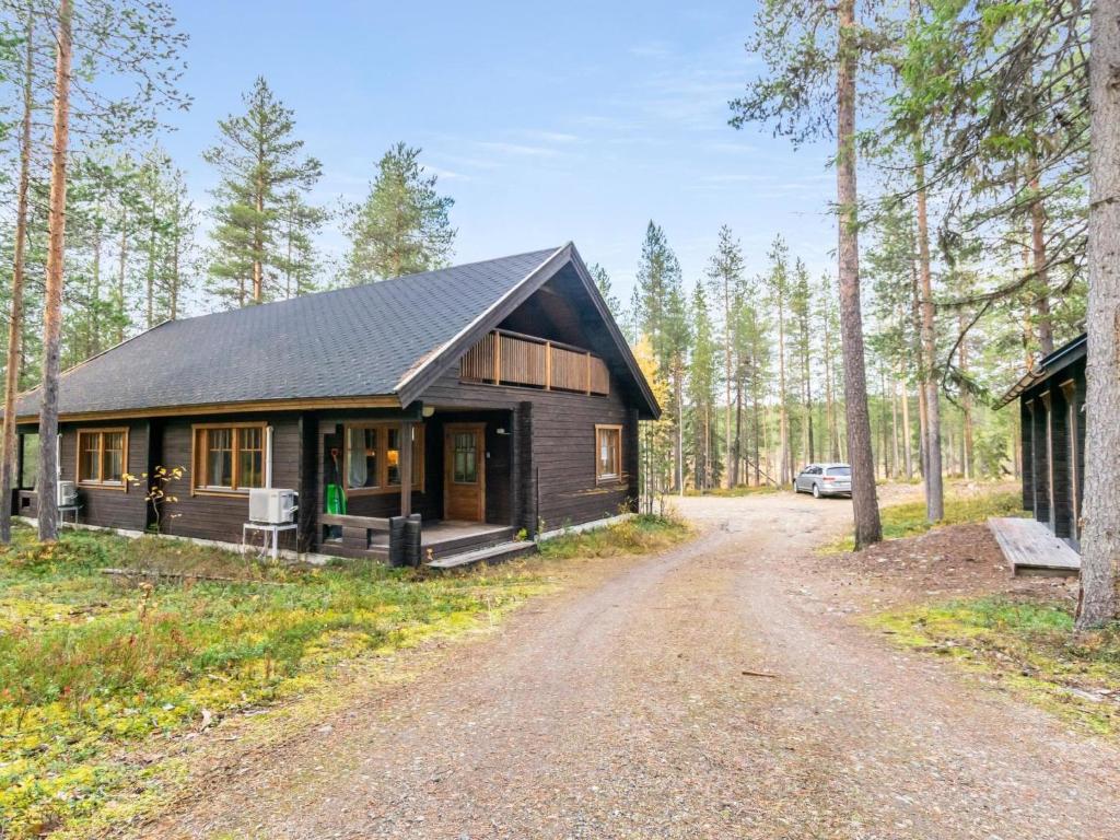 a cabin in the woods with a dirt road in front at Holiday Home Saukonpiilo 2 by Interhome in Pyhätunturi