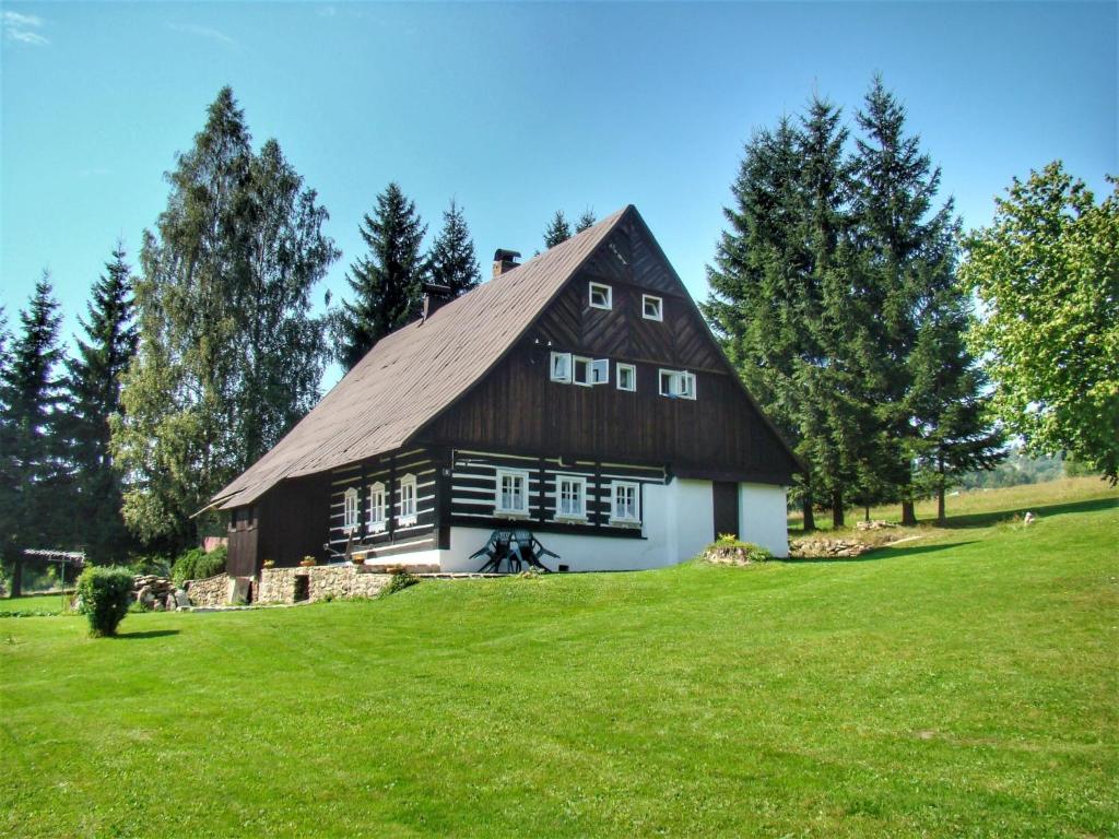 a barn on a field with green grass at Holiday Home Paseky nad Jizerou by Interhome in Paseky nad Jizerou