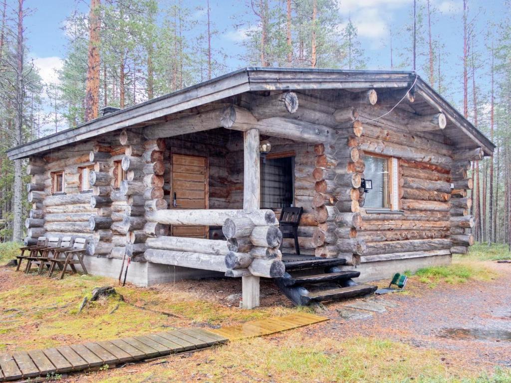 Cette cabane en rondins dispose d'une terrasse couverte, d'une table et de chaises. dans l'établissement Holiday Home Hakojärven kelomajat 2 by Interhome, à Ruka