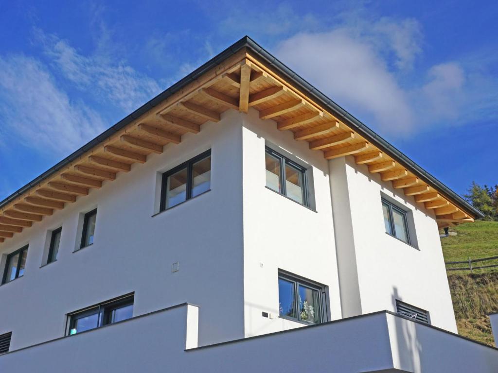 a white house with a gambrel roof at Apartment Apart Handle by Interhome in Fliess