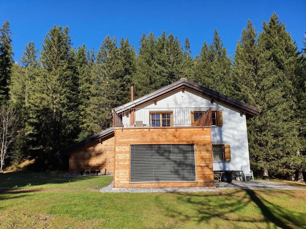 a house with a garage in front of trees at Apartment Lieptgas by Interhome in Lenzerheide