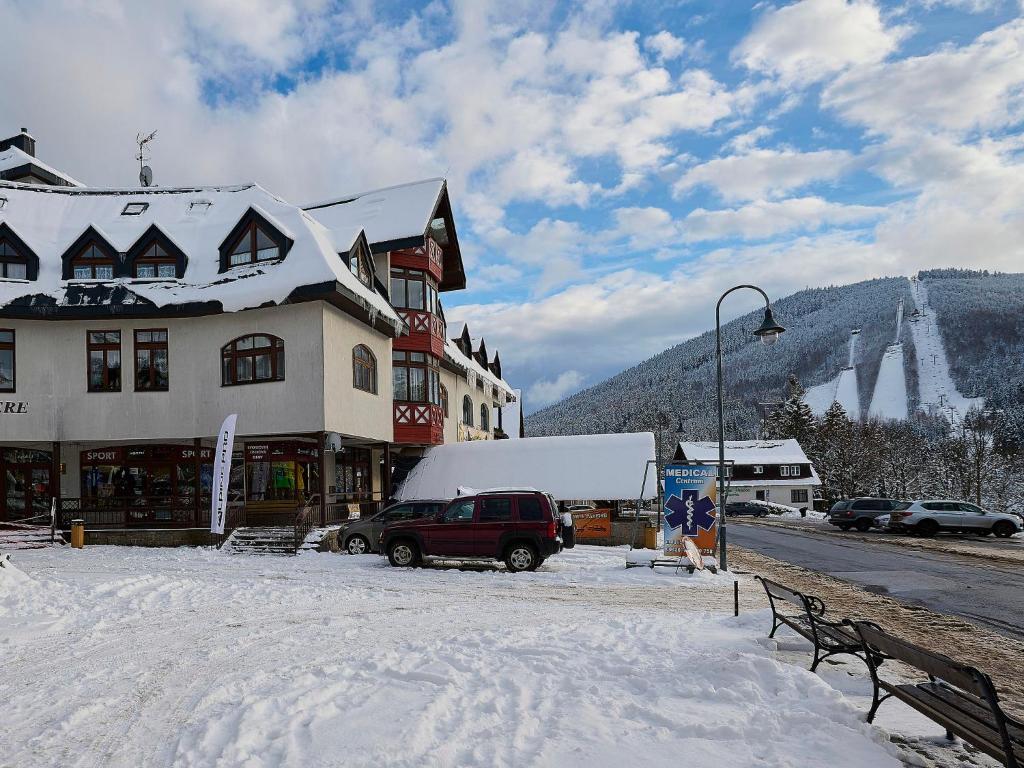 a snow covered street in front of a building at Apartment Harrachov 613-1 by Interhome in Harrachov