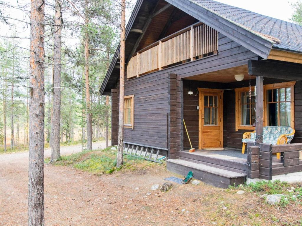 uma cabana na floresta com um alpendre e uma porta de madeira em Holiday Home Saukonpiilo 1 by Interhome em Pyhätunturi