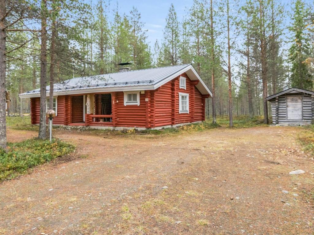 a cabin in the woods with a dirt road in front at Holiday Home Hovimartti by Interhome in Pyhätunturi