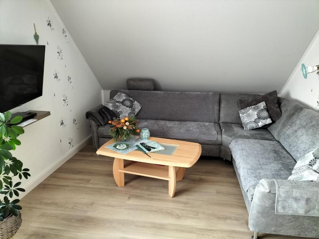 a living room with a couch and a coffee table at Ferienwohnung Brentano_ 65230 in Moormerland