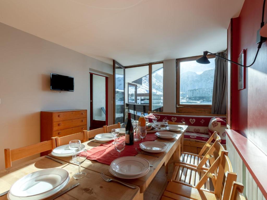 ein Esszimmer mit einem Holztisch mit Tellern darauf in der Unterkunft Apartment Les Roches Rouges by Interhome in Tignes