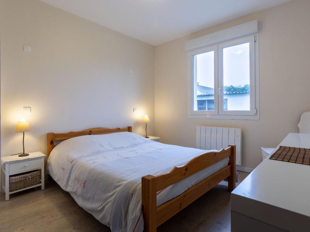 a bedroom with a large bed and a window at Holiday Home La Plage by Interhome in Denneville