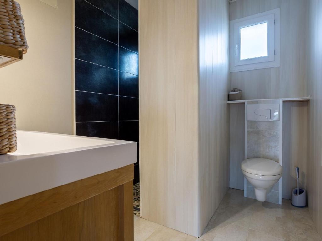 a bathroom with a toilet and a sink at Holiday Home La Plage by Interhome in Denneville