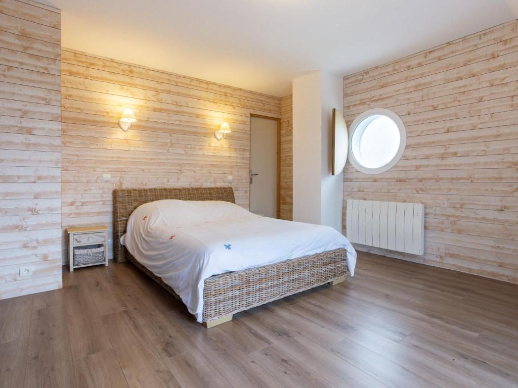 a bedroom with a bed and a brick wall at Holiday Home La Plage by Interhome in Denneville