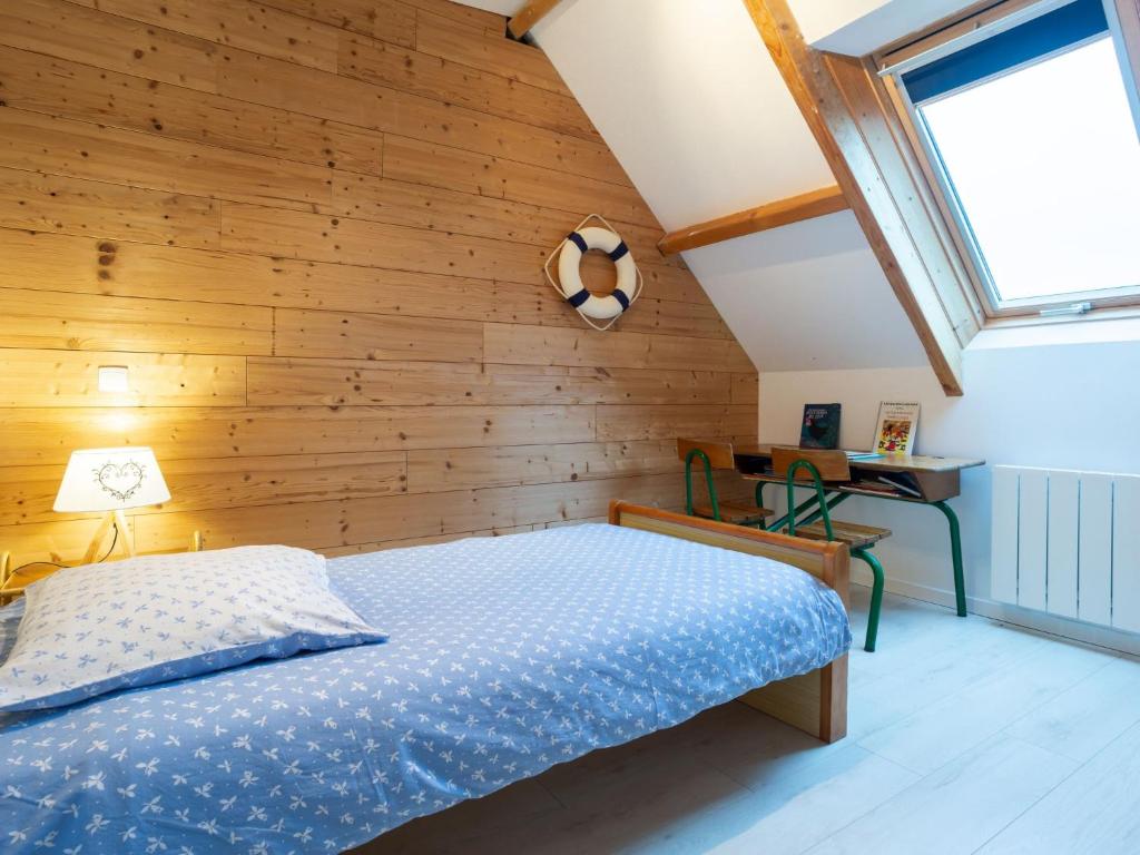 a bedroom with a bed and a wooden wall at Holiday Home La Plage by Interhome in Denneville
