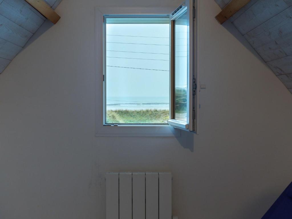 a window in a white room with a radiator at Holiday Home La Plage by Interhome in Denneville