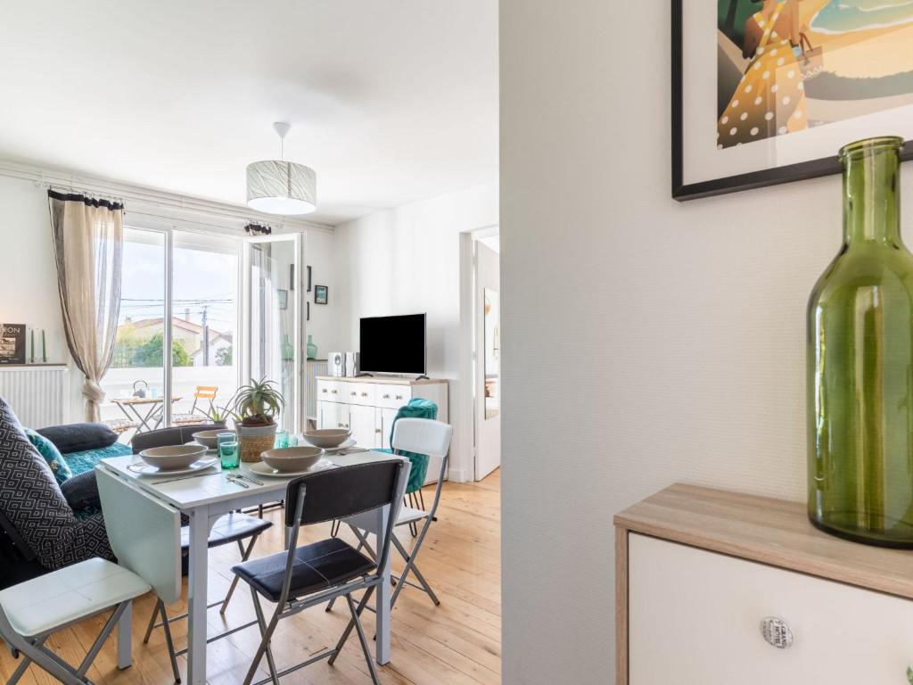 jadalnia i salon ze stołem i wazonem w obiekcie Apartment Coutant-2 by Interhome w mieście Royan