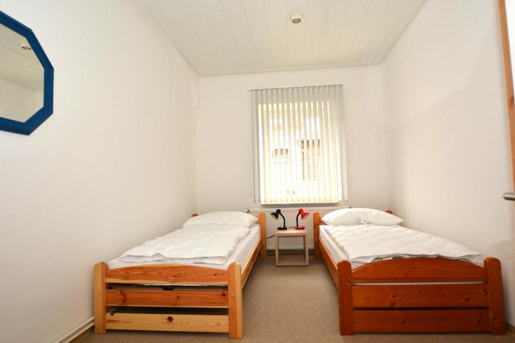 2 Einzelbetten in einem Zimmer mit Fenster in der Unterkunft Dr.Stein in Borkum