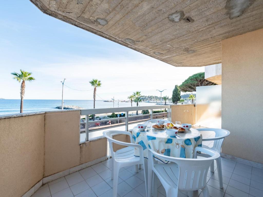 einen Tisch und Stühle auf einem Balkon mit Meerblick in der Unterkunft Apartment Le Palazzo del Mar-12 by Interhome in Cavalaire-sur-Mer