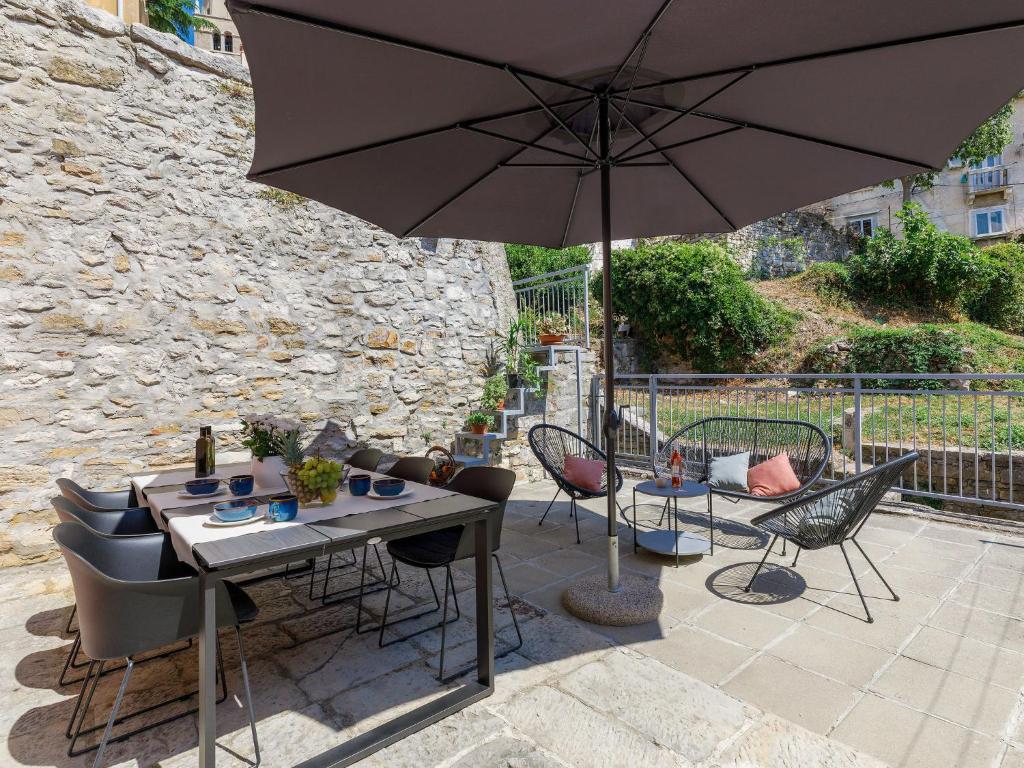 einen Tisch und Stühle mit Sonnenschirm auf einer Terrasse in der Unterkunft Holiday Home Casa Negri by Interhome in Labin