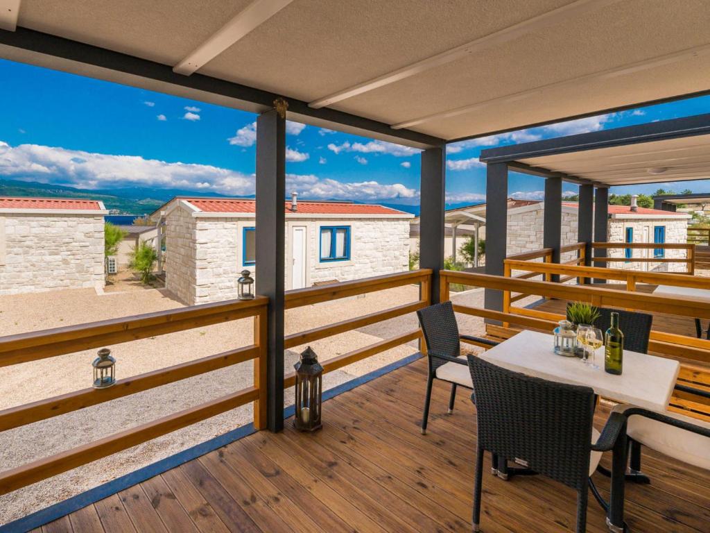 a patio with a table and chairs on a deck at Holiday Home Seaside mobile home by Interhome in Šilo