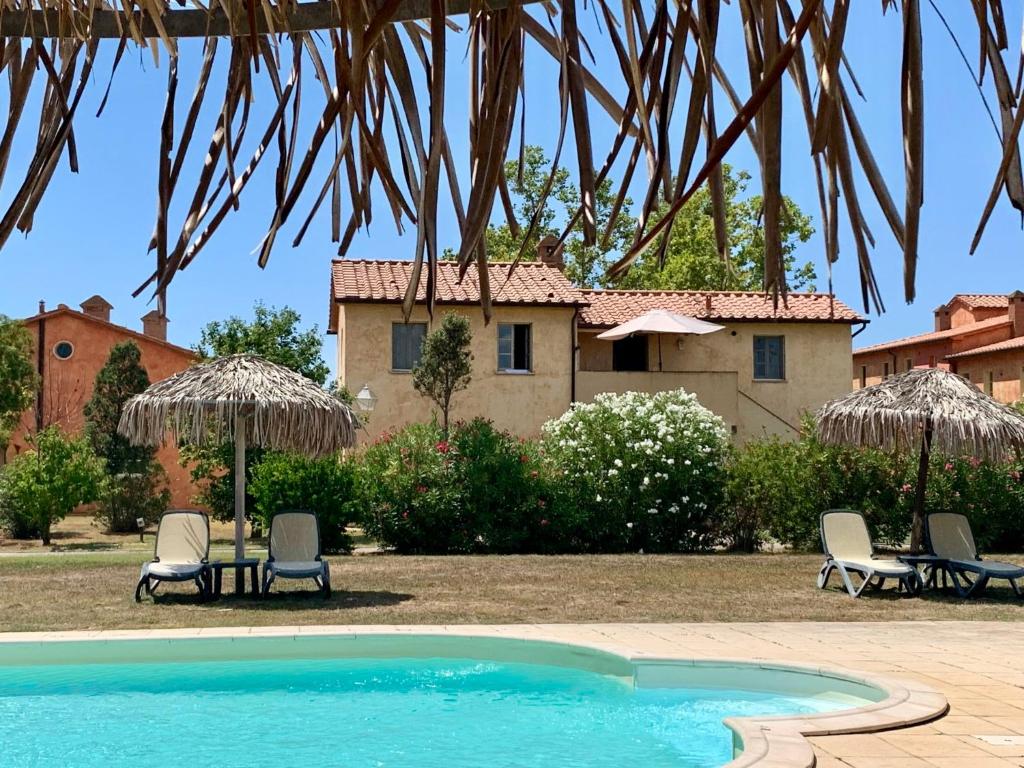 een zwembad met stoelen en parasols en een huis bij Apartment Quercia Alta by Interhome in Le Case