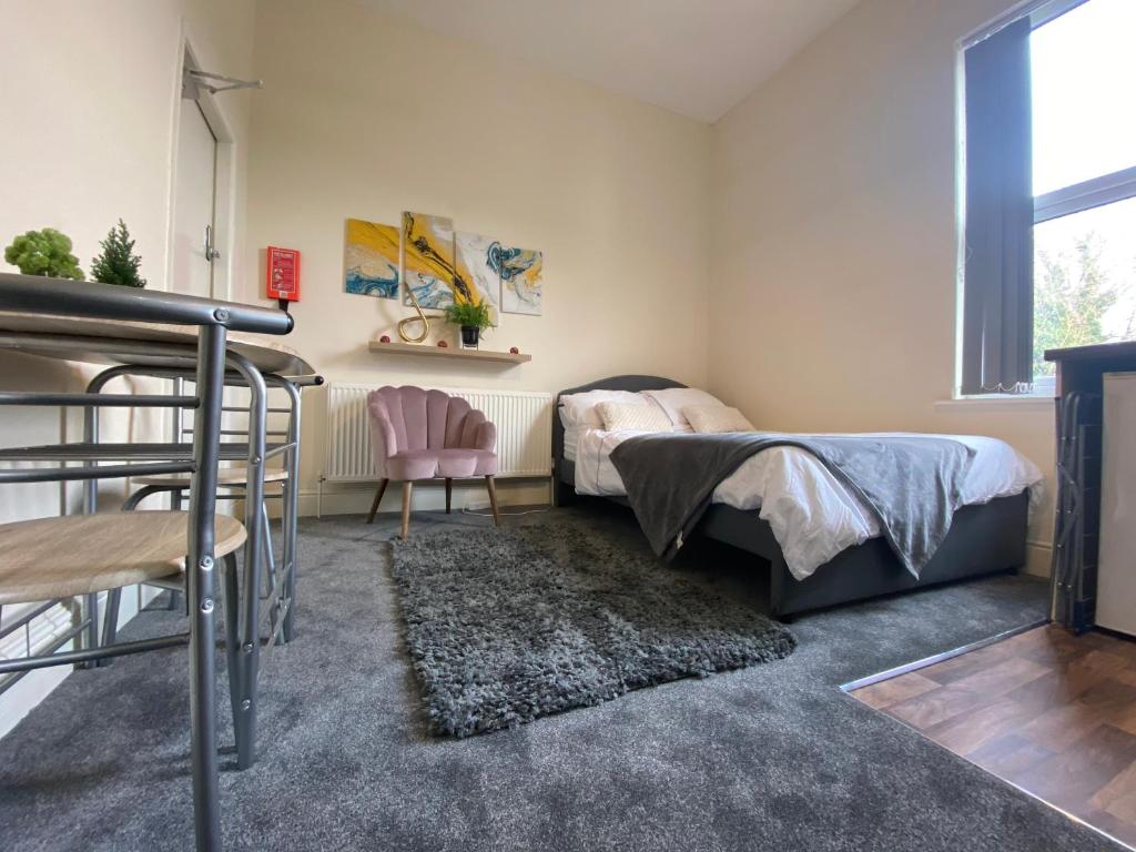 a bedroom with a bed and a chair and a window at Cosy studio apartment - recently renovated! in Mansfield