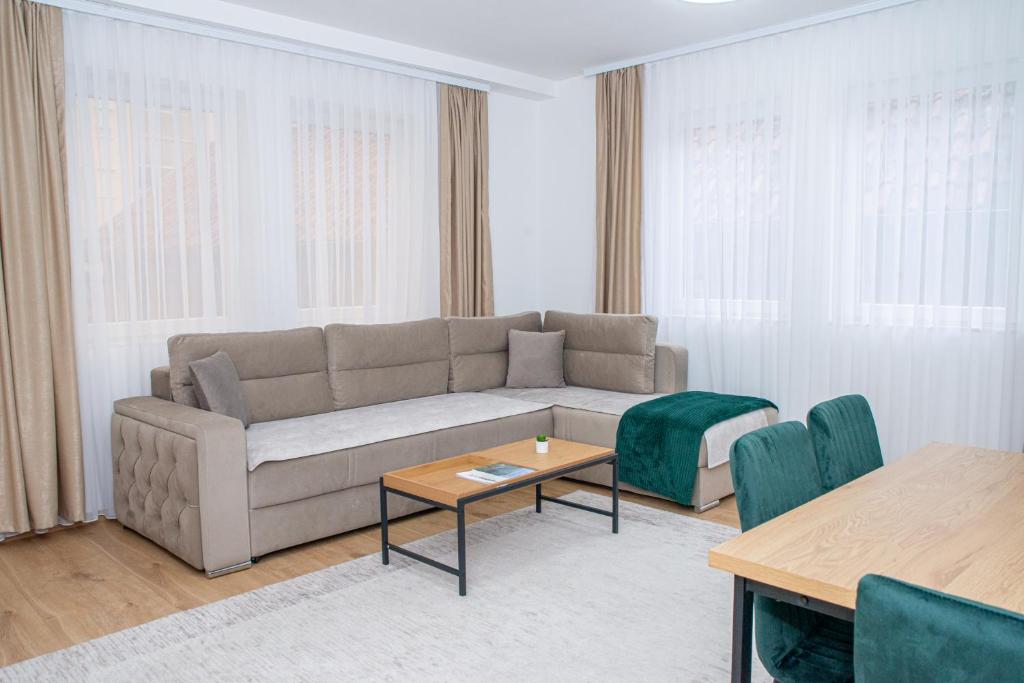 a living room with a couch and a table and chairs at CENTRAL Aparments in Novi Pazar