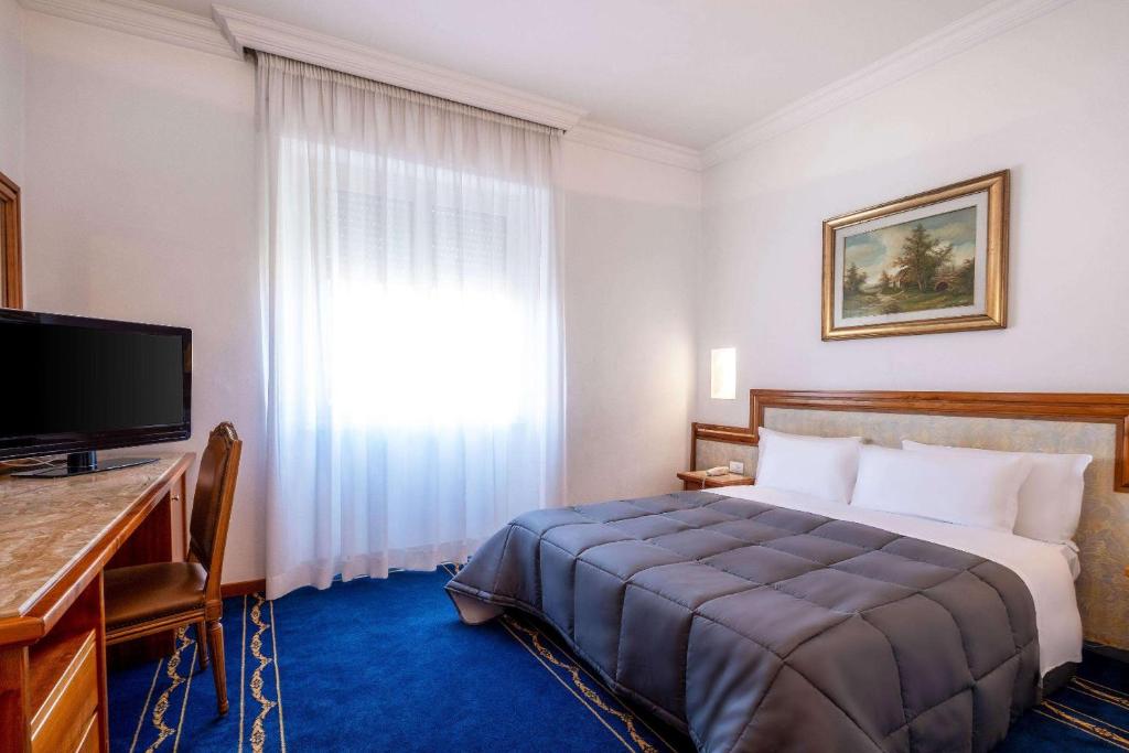 una camera d'albergo con letto e finestra di Quality Hotel Nova Domus a Roma