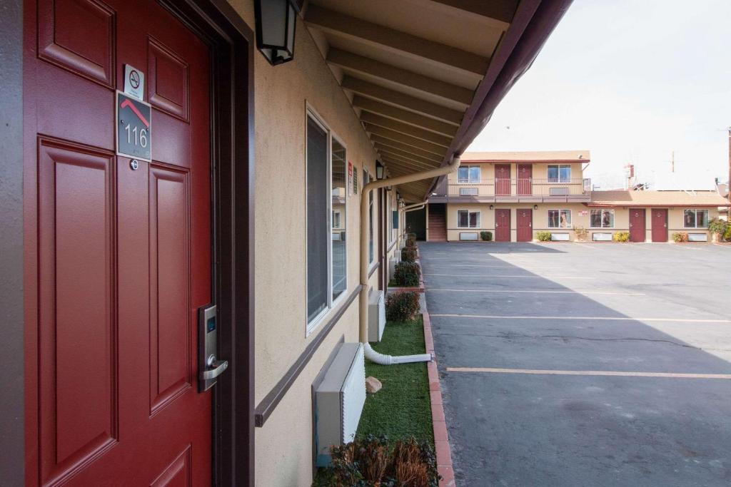 una puerta roja de un edificio al lado de un estacionamiento en Quality Inn Bishop near Mammoth, en Bishop