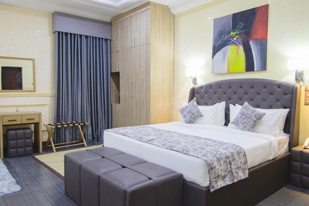 a hotel room with a large bed and a table at BON Hotel Asokoro Residence in Abuja