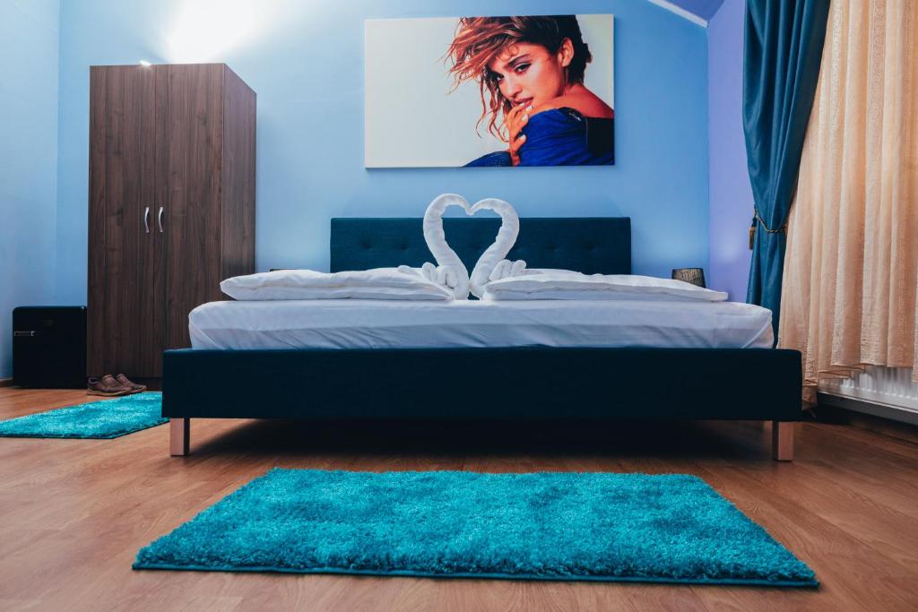 a bedroom with a bed with blue walls and blue rugs at GUITAR - Camere de Inchiriat in Sibiu