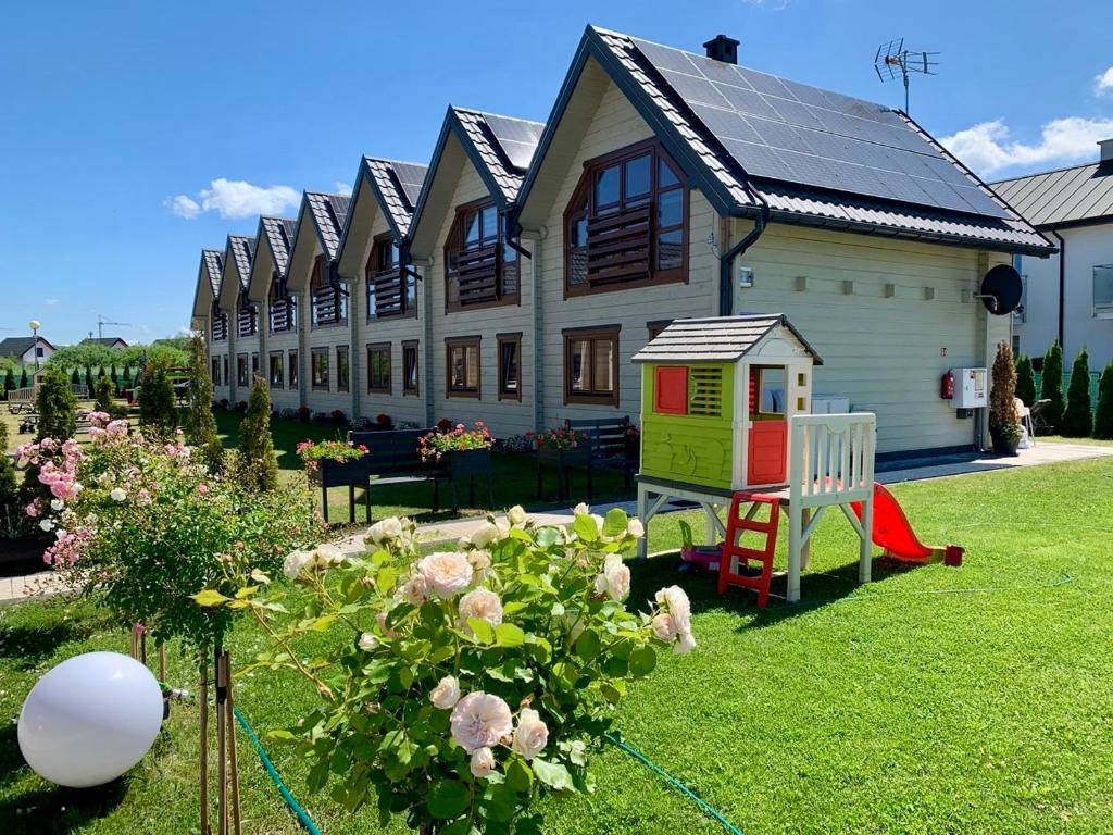 uma casa com um parque infantil e uma casa de brincar em Domki letniskowe Gala II em Grzybowo