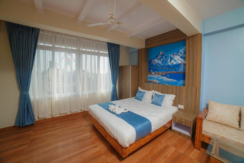 um quarto com uma cama grande e uma cadeira em Lotus Apartment em Pokhara