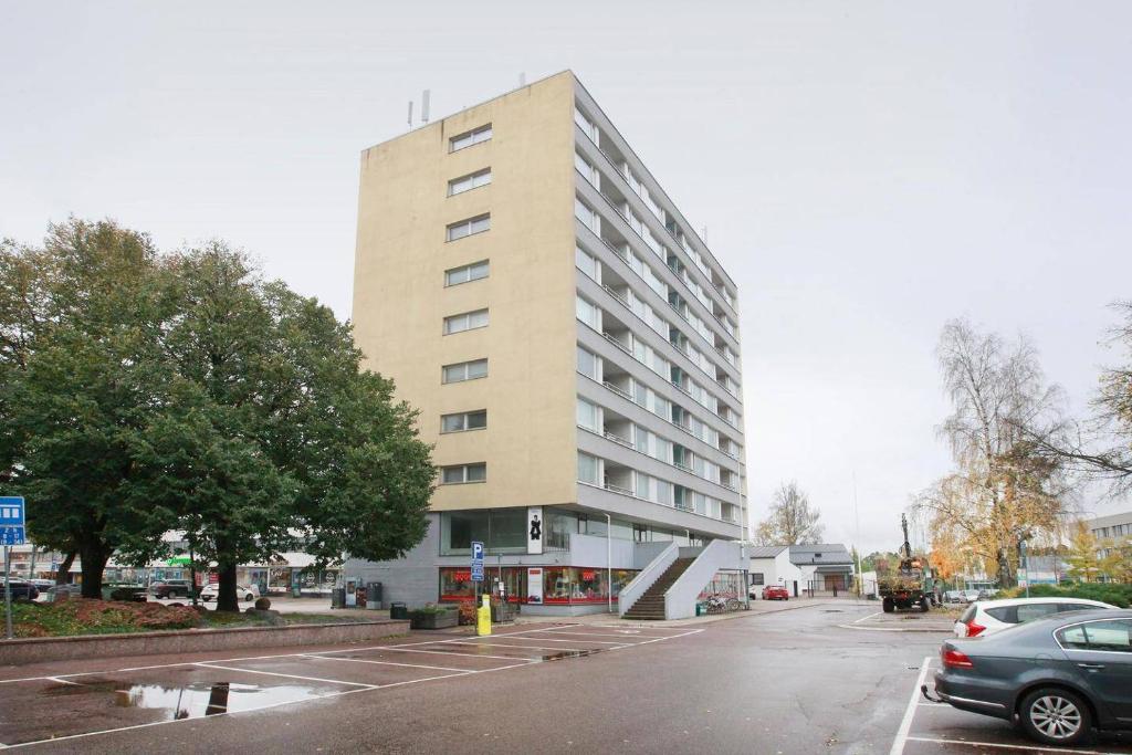 een groot gebouw aan een straat met een parkeerplaats bij Kotka Orange Apartments Tapuli in Kotka