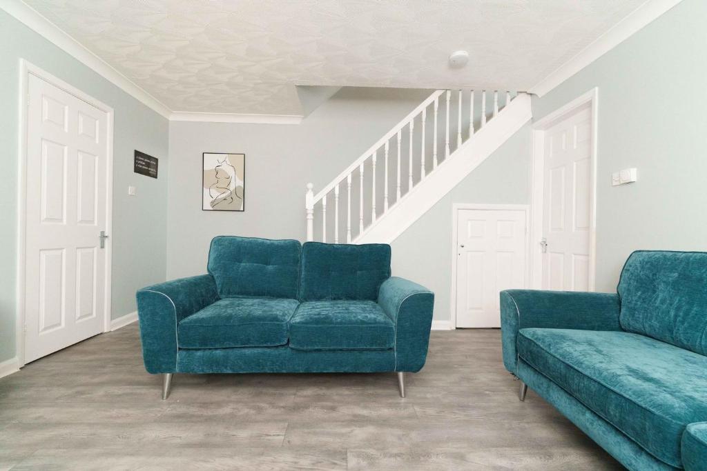 un soggiorno con 2 sedie blu e un divano di Huntington House with Free off road parking a York