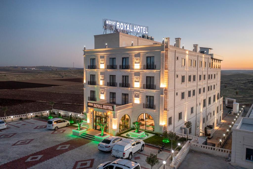 Midyat Royal Hotel & Spa في مِديات: اطلالة جوية على فندق فيه سيارات متوقفة في مواقف