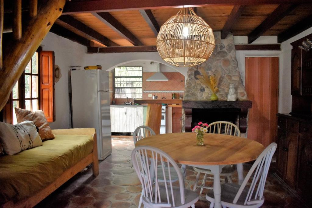 Cabañas La Oma Intiyaco في Atos Pampa: مطبخ وغرفة طعام مع طاولة وكراسي