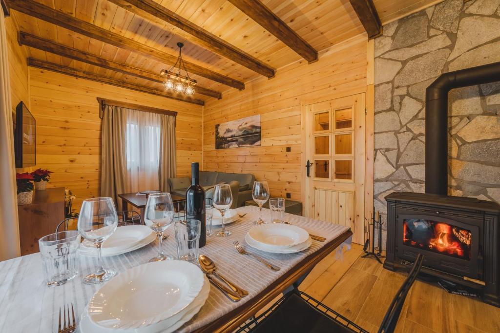 a dining room with a table and a wood stove at Eco Village & Chalets Green Heaven in Mojkovac