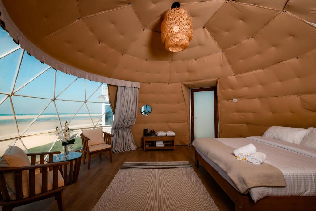 una camera da letto con una grande stanza con un grande soffitto di Siniya Island Leisure Campground Umm Al Quwain a Umm Al Quwain