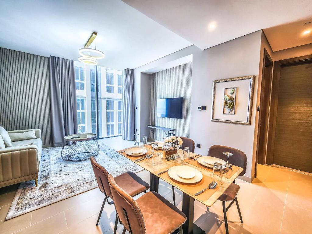 ein Esszimmer mit einem Tisch und Stühlen sowie ein Wohnzimmer in der Unterkunft STAY BY LATINEM Luxury 2BR Holiday Home CV A2509 near Burj Khalifa in Dubai