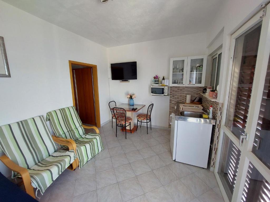 salon z 2 krzesłami oraz kuchnia ze stołem w obiekcie Apartment in Okrug Gornji 6196 w mieście Okrug Donji