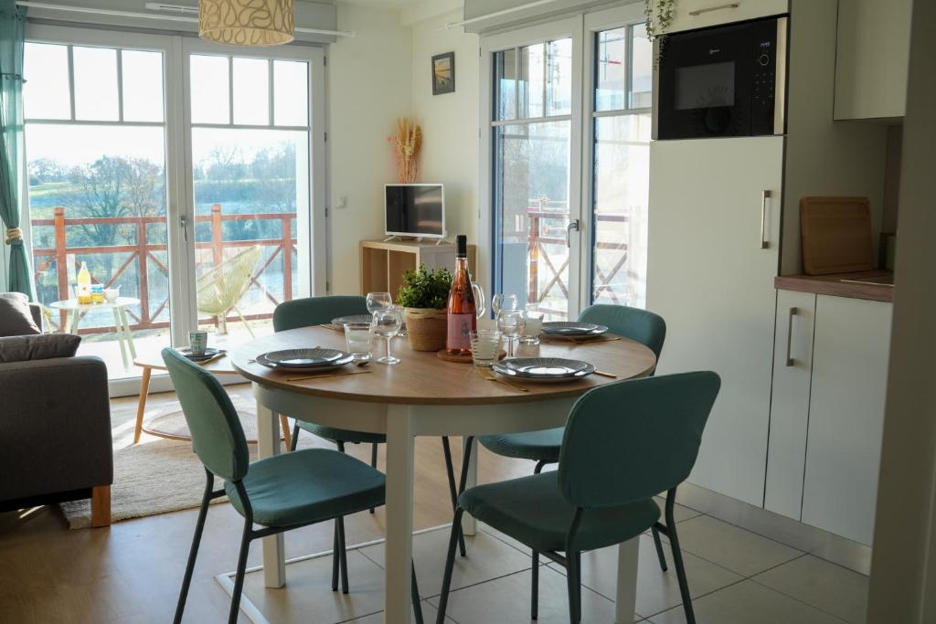 une salle à manger avec une table et des chaises et une cuisine dans l'établissement Appartement neuf, avec terrasse, parking et ascenseur, à Saint-Valery-sur-Somme