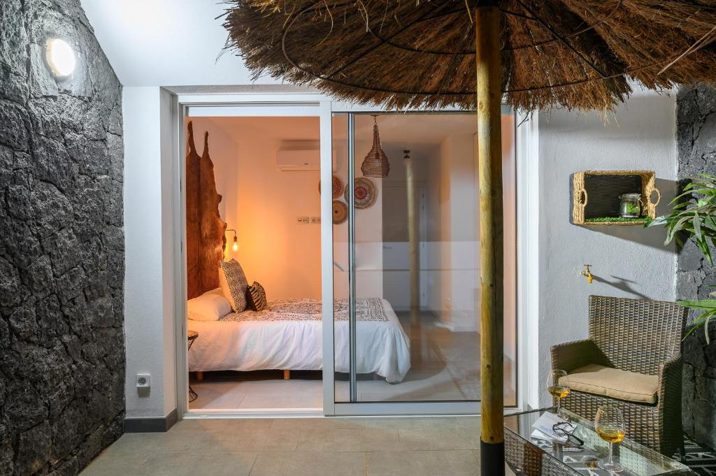 a room with a bed and a glass door at Pachamama House-near the beach, fast wifi, air-con and SAT tv in Playa Blanca