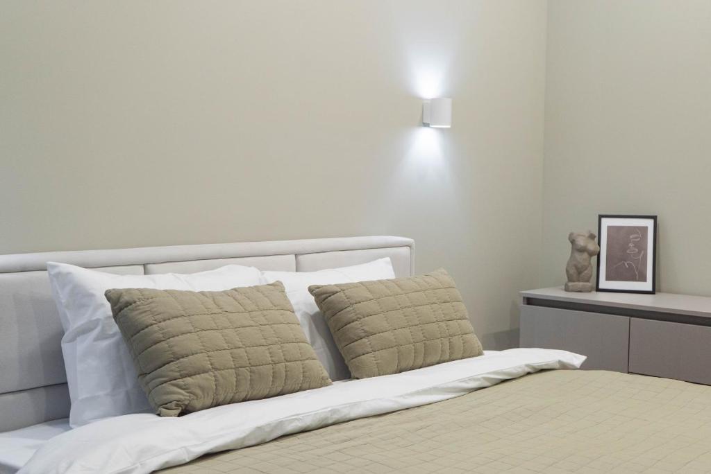 a bedroom with a bed with two pillows at RentWill apartments Oliva in Chişinău