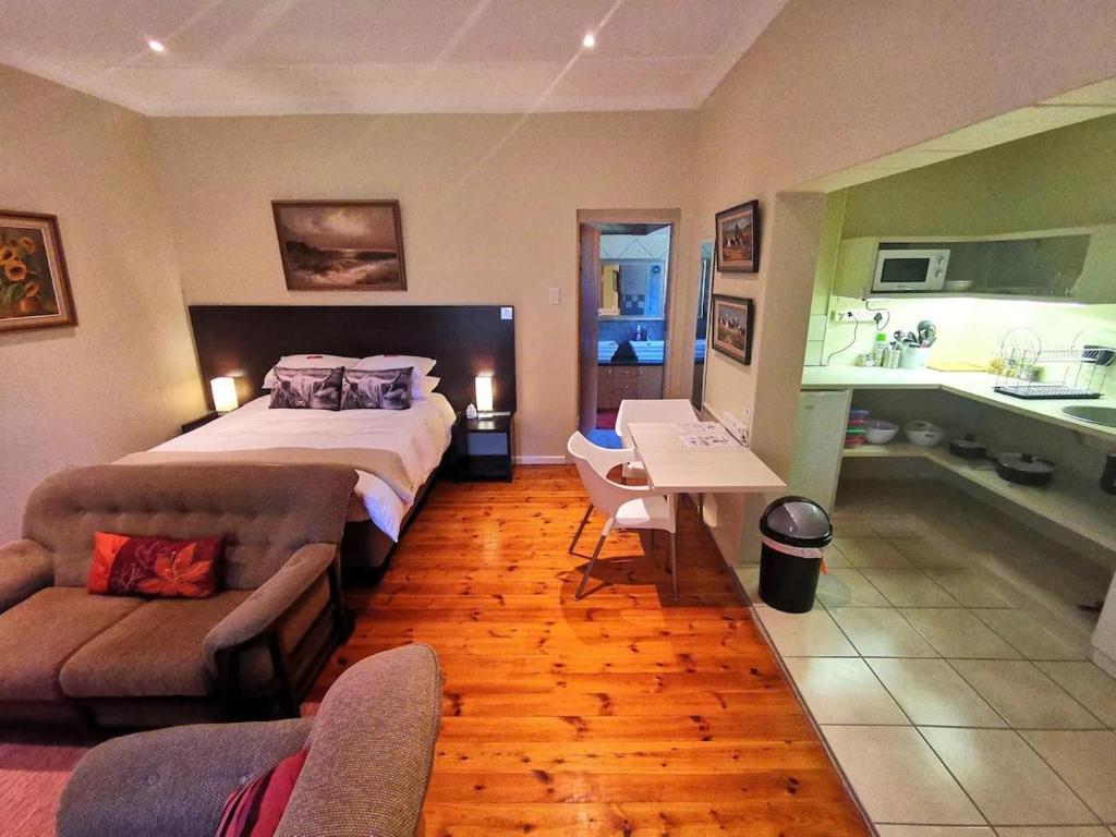 a bedroom with a large bed and a bathroom at Cozy Manor Guestrooms in Lyttelton