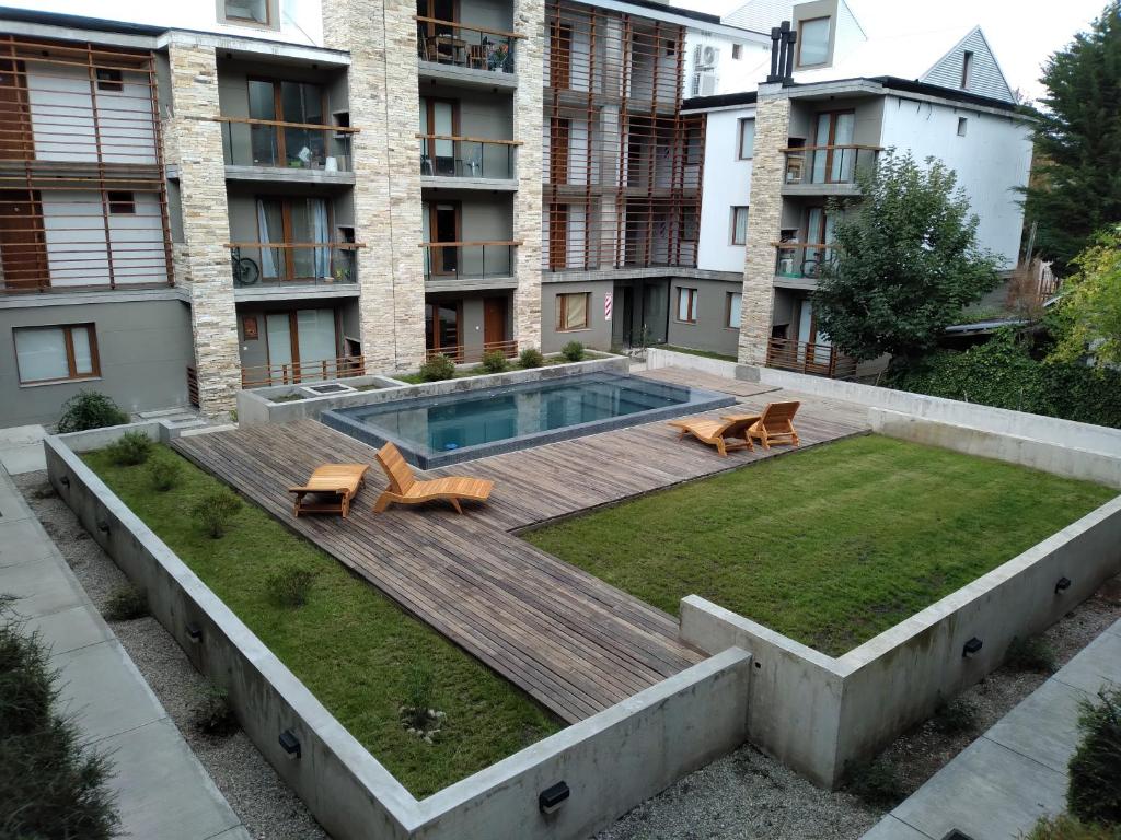 un patio trasero con terraza de madera y piscina en Lo de Marcelo en San Martín de los Andes