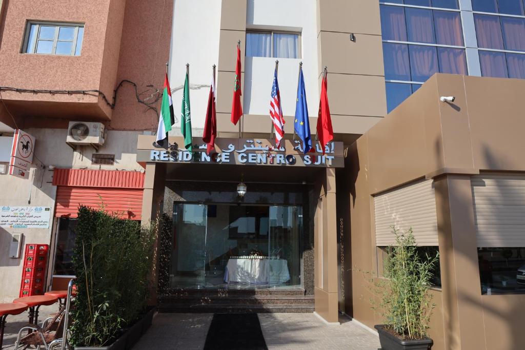 een hotelingang met vlaggen van verschillende landen bij RESIDENCE CENTROSUIT in Laayoune