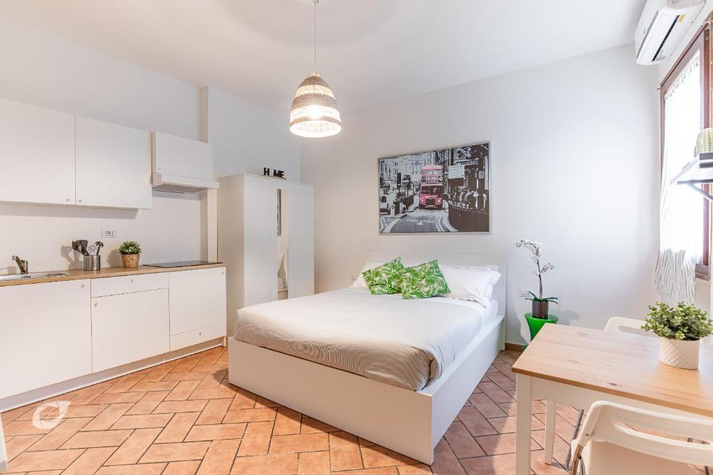 a bedroom with a bed and a kitchen with a table at Duomo Central Studio in Florence
