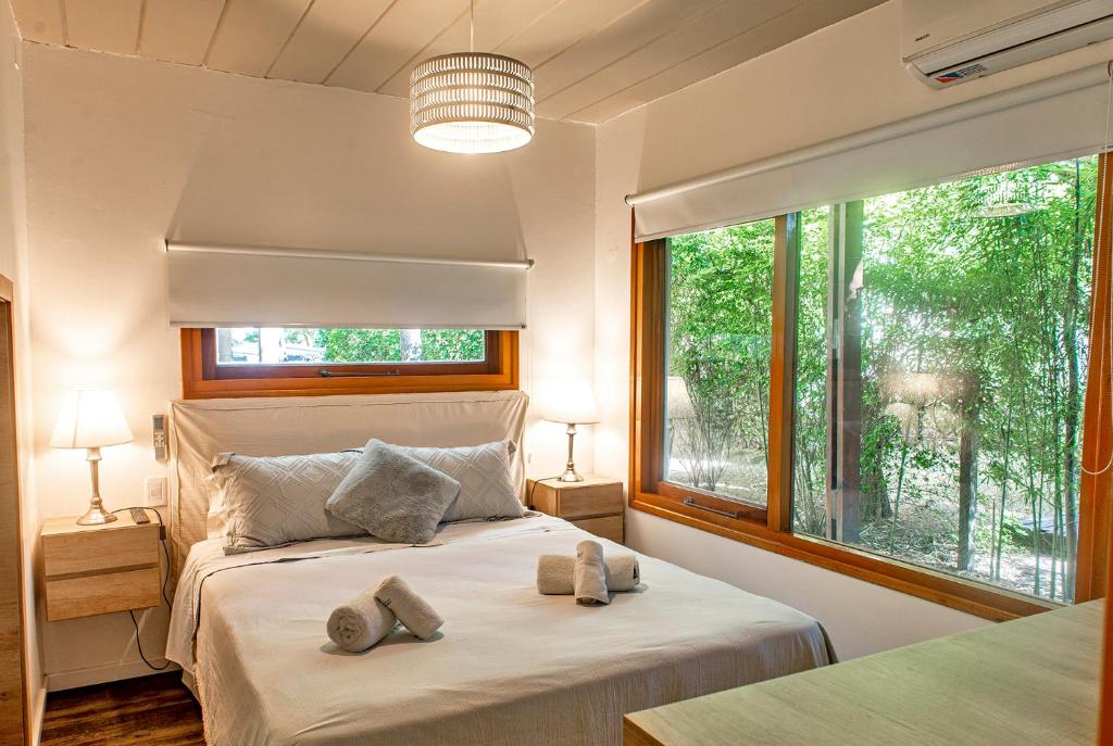 1 dormitorio con cama y ventana grande en Terrazas del Bosque Aparts en Mar de las Pampas